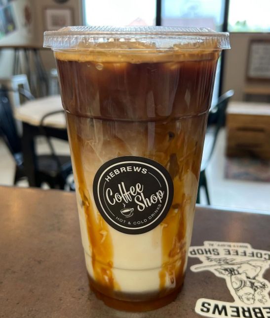 An iced caramel coffee drink in a Hebrews Coffee Shop cup