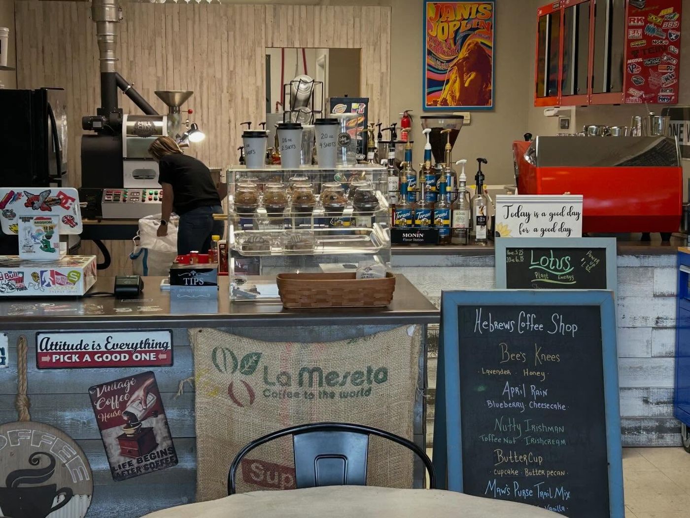 Inside Hebrews Coffee Shop — the counter, coffee roaster, syrups, and the signature drink chalkboard